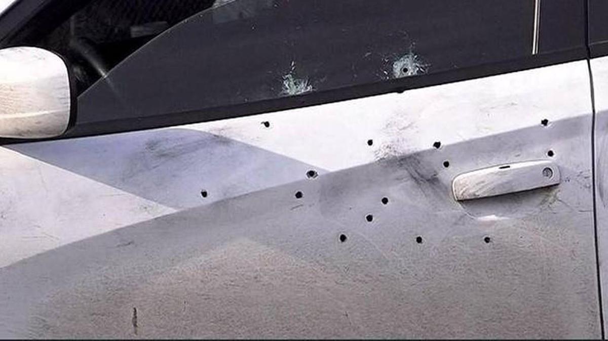 Gunfire left bullet holes in the driver’s side door of a white Dodge sedan, killing 26-year-old Ronald Washington and leaving a woman critically injured.