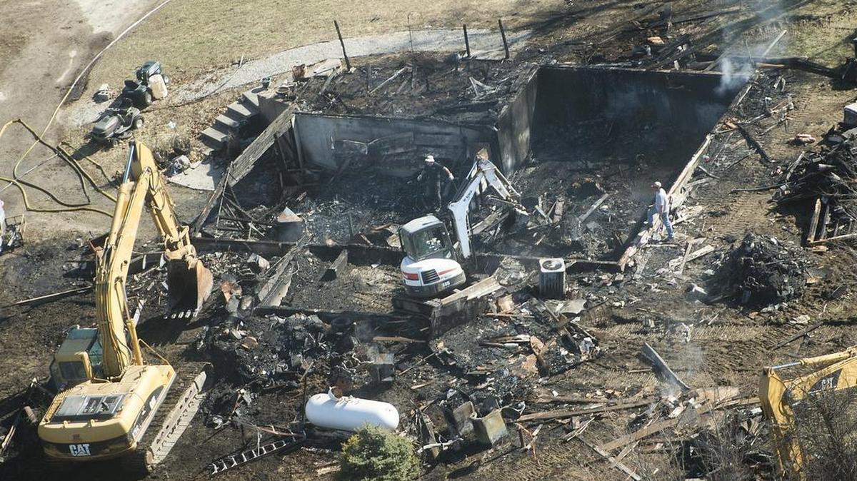 Fire officials and authorities working with heavy equipment investigated the remains of a house in the 3700 block of Buena Vista Road on Saturday, Feb. 20, 2016, just south of Edgerton, in Platte County.