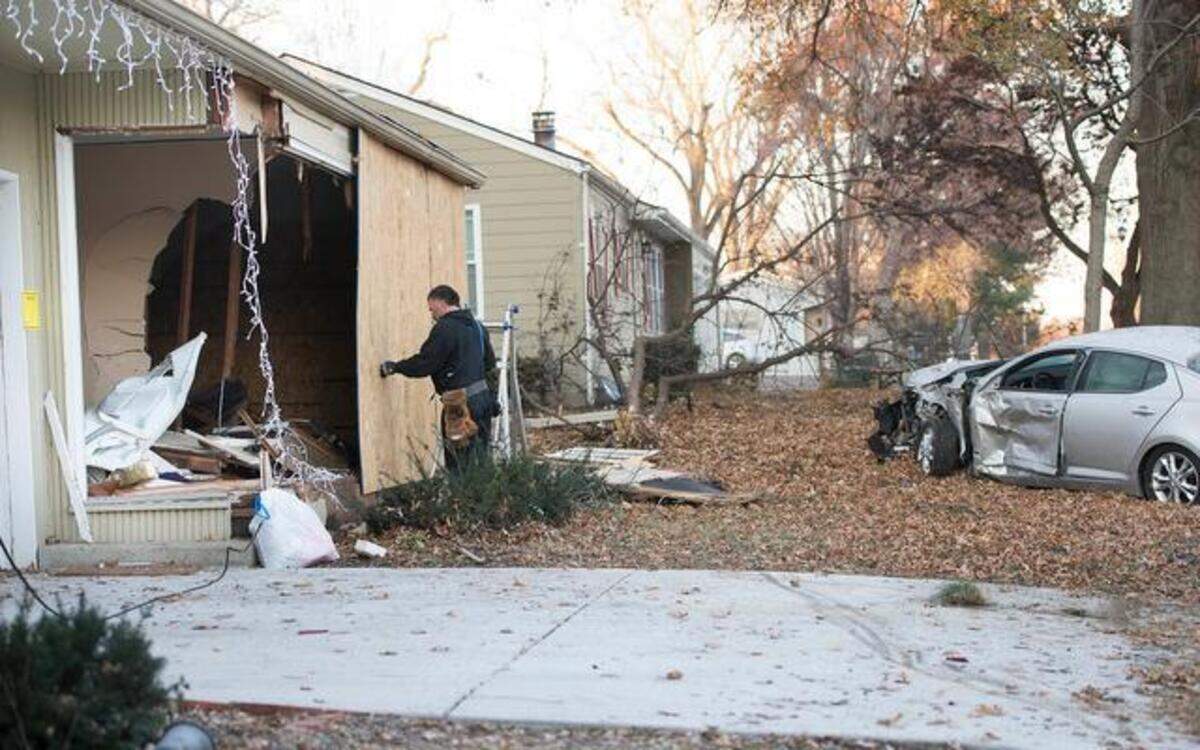 
Kevin Turley of Repairs Unlimited boarded up a duplex near 79th and Antioch Road that was damaged early Thursday in a carjacking crash. Two carjacking suspects led Kansas City police on a chase that ended when the driver crashed a stolen pickup into the duplex. The stolen pickup smashed into a car (right) parked on the driveway, damaging the car and forcing the car into a tree in the front yard.
