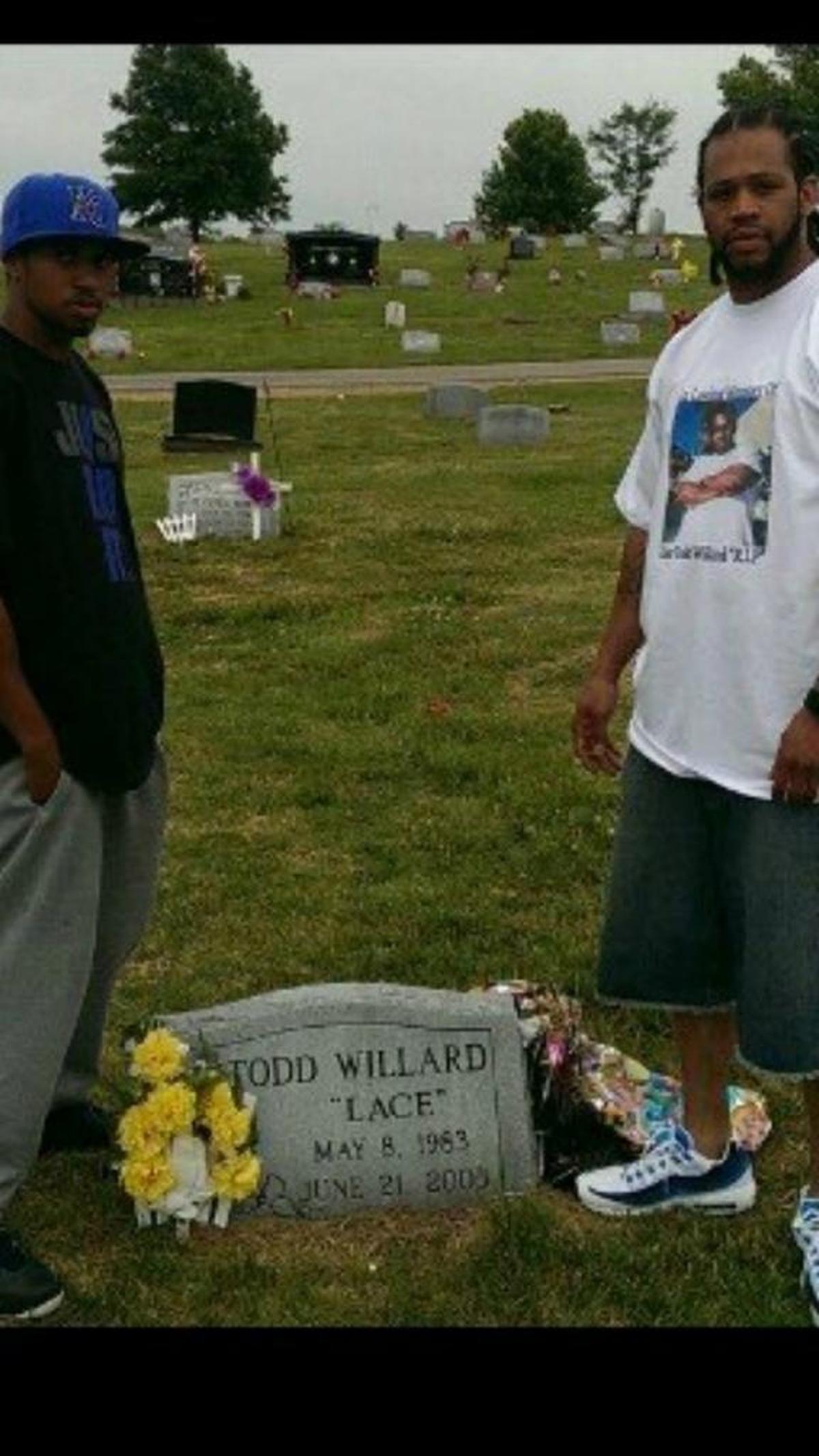 David Willard (right) and a friend at Willard’s brother’s grave. Willard is wearing a T-shirt printed with his brother’s face.