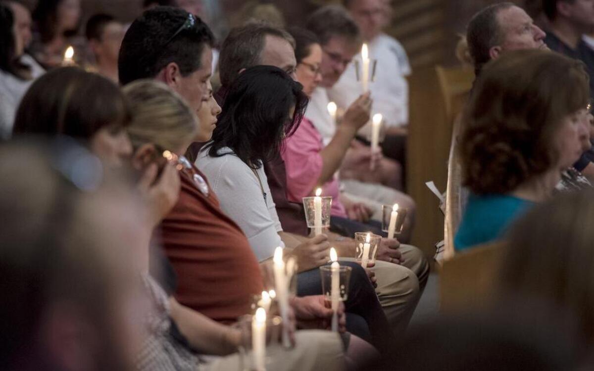 
Parishioners held candles on Sunday during a prayer vigil at Northgate Baptist Church in Kansas City for a Northland mother and her daughter who were critically injured in a July 7 shooting at their home. The suspect in the attack is still at large.
