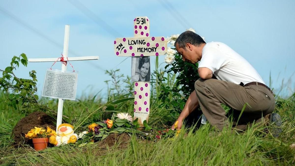 Nearby resident Farhad Mohammadi knelt in prayer beside a memorial for Caitlin Vogel on Wednesday at 191st Street and Nall Avenue in Stilwell. “God bless her soul,” Mohammadi said.