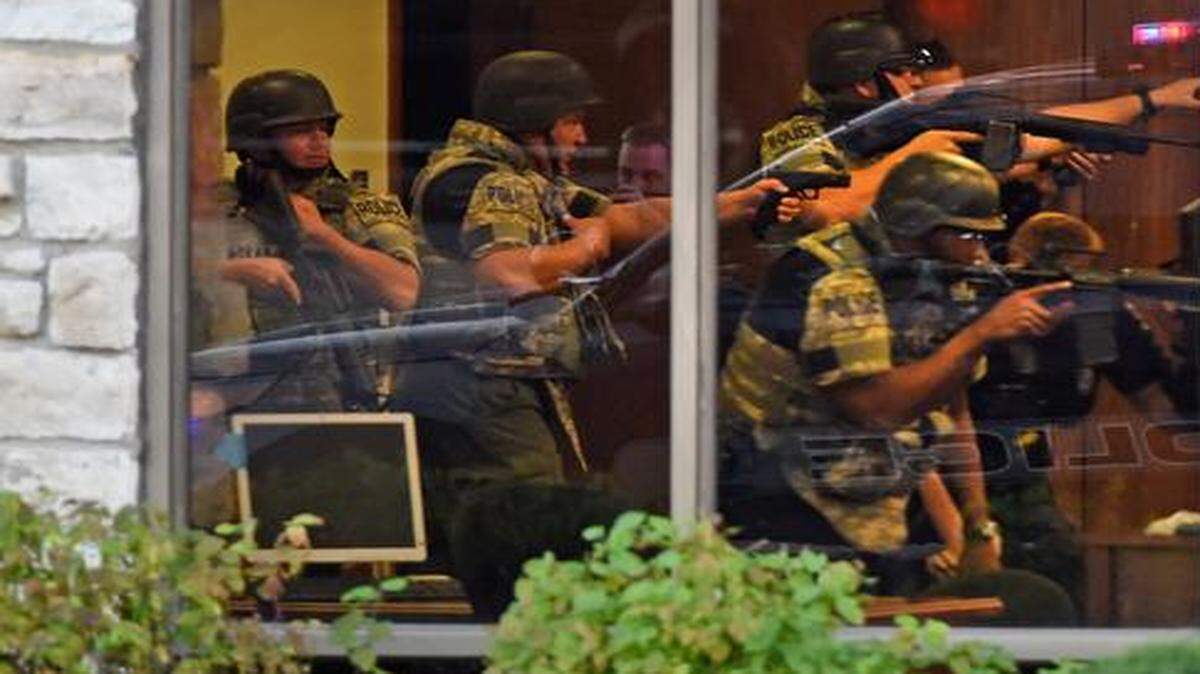 
Police tactical units had their weapons drawn as they entered a Bank of America branch at 95th Street and Mission Road in Overland Park that was the scene of a robbery Wednesday. Two people were injured in the incident, and two men were taken into custody. 
