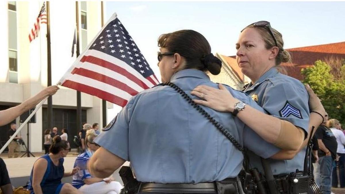Kansas City, Kan., Police Sgt. Angela Joyce (left) and Sgt. Tobi Wolf consoled each other as they honored fallen Kansas City, Kan., police detective Brad Lancaster during a candlelight vigil Tuesday.