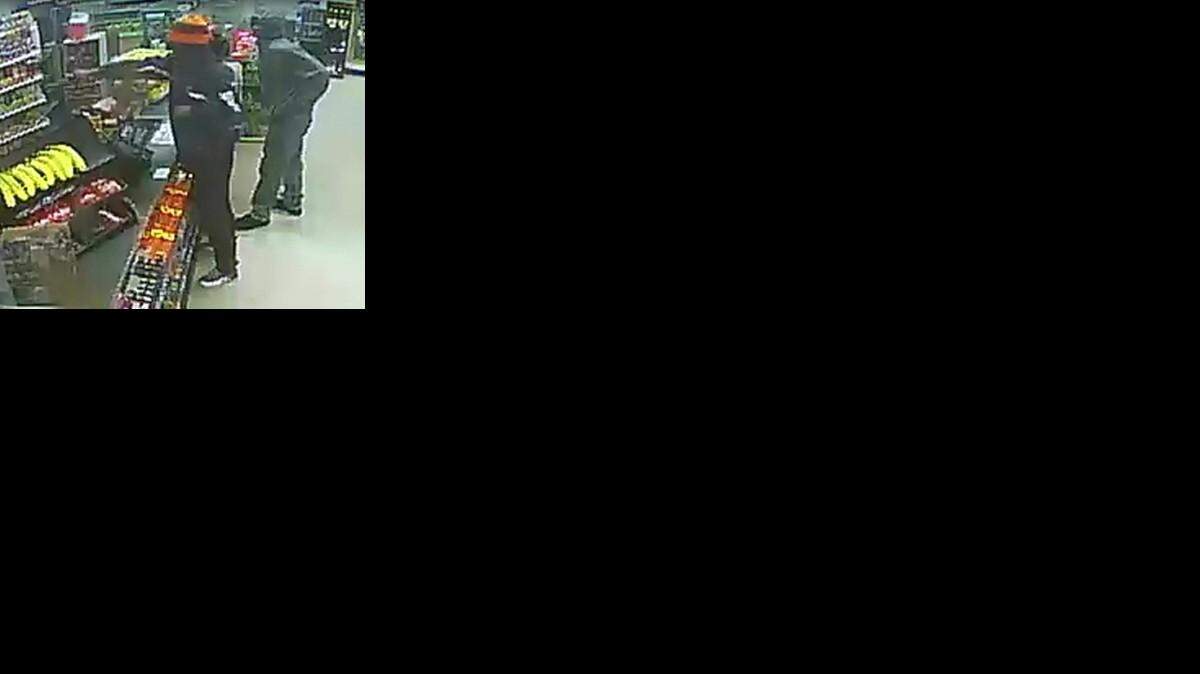 
A surveillance photo shows a man with an outstretched arm holding a pistol during a robbery of a 7-Eleven in south Kansas City Tuesday evening. Police are hoping someone would identify the two men in the photo.
