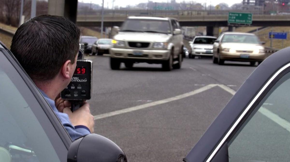 A Kansas City police officer uses a radar gun to catch speeders in a 45-mph zone. The number of traffic citations issued in Kansas City has dropped in recent years in part, police officials say, because traffic officers have expanded their duties to homicides and other significant crime scenes.