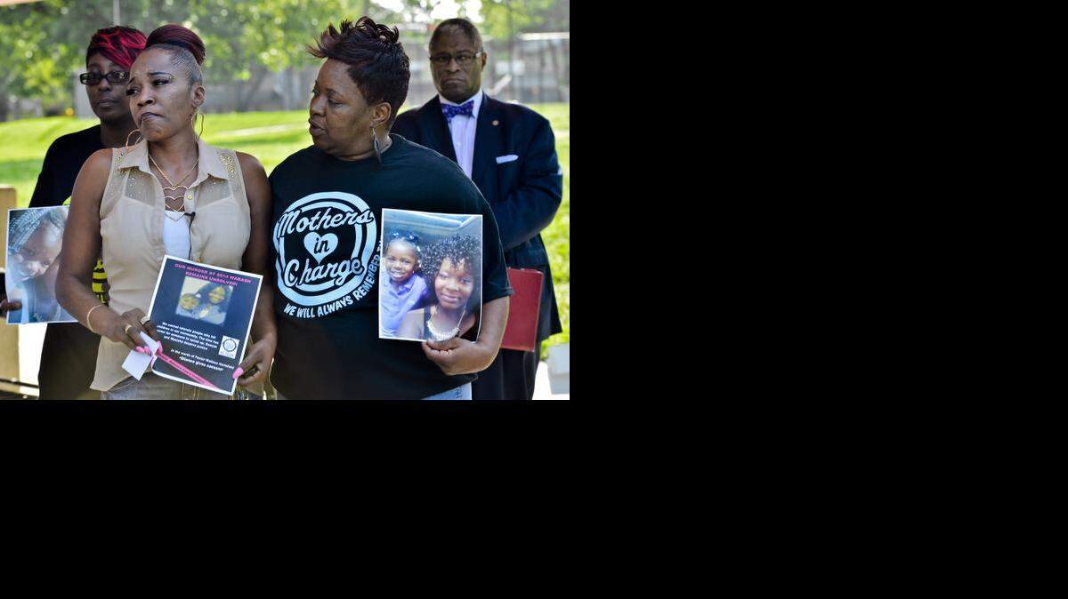 
Cheryl Turner (left) and Rosilyn Temple listened as officials spoke to a crowd Friday about the need to find the person who killed Turner’s granddaughter and daughter one year ago. Mayor Sly James (right) gave Turner his support.
