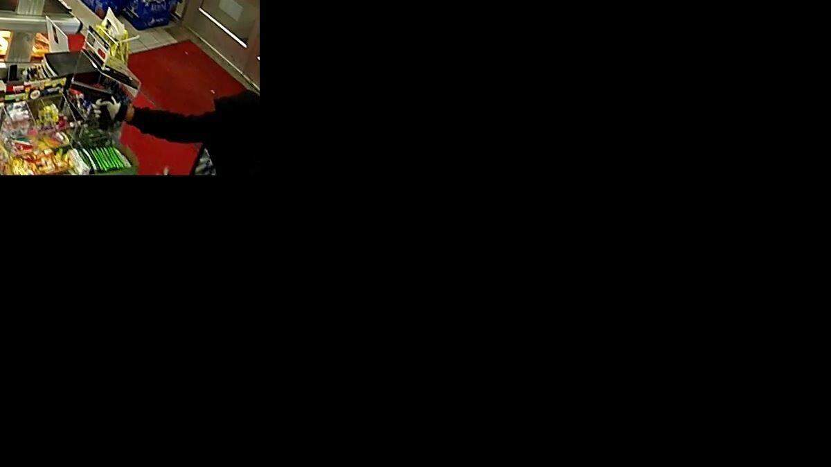 
An alleged robber points a handgun during a robbery of a Shawnee store early Sunday.
