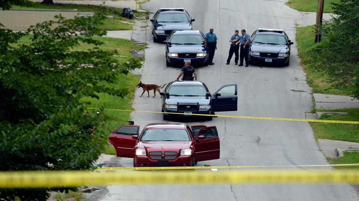 
Kansas City police investigated after finding a Dodge Magnum (front) that had rammed an officer’s motorcycle earlier and sped off as the officer shot at it. Two men were taken into custody.

