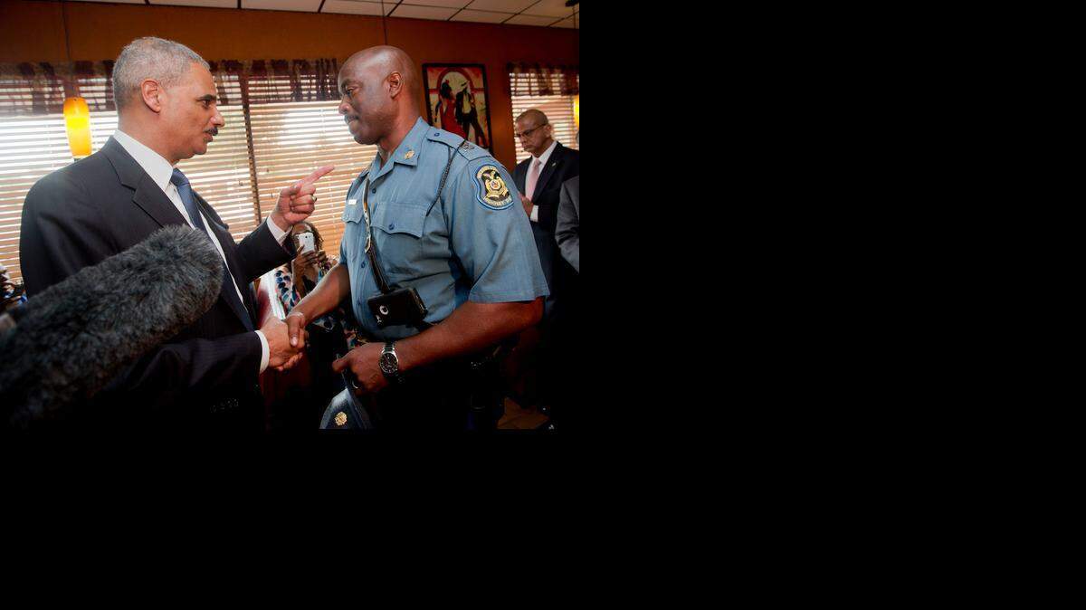 
U.S. Attorney General Eric Holder (left) arrived in Missouri on Wednesday, the day a grand jury began hearing evidence in the Aug. 9 police shooting. Holder met with Highway Patrol Capt. Ron Johnson in Florissant, Mo. 
