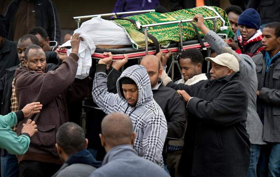 After mourners gathered to pray for the soul of 15-year-old body of Abdisamad Sheikh-Hussein, his father, Abdullahi Mohamud (left), and other men carried the teen’s body away for burial from the Islamic Center of Greater Kansas City.