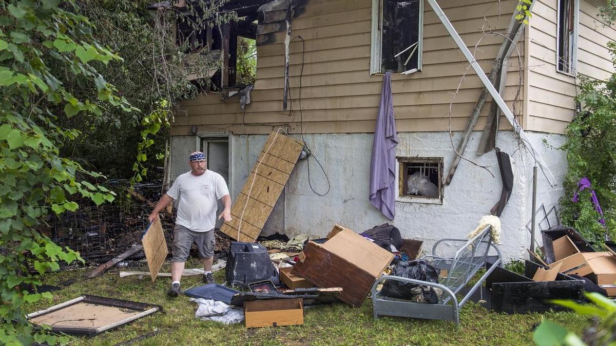
Bill Brown of Damage Control & Restoration carried plywood to cover the windows of a fire-damaged house in the 4400 block of Elmwood Avenue in Kansas City on June 23.
