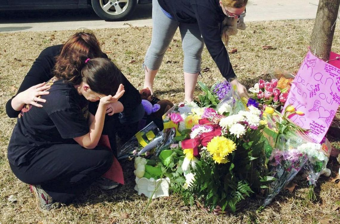 Stacey Herman, mother of Hailey Owens, (foreground left) is consoled by Sara Wells, as family member Teri Nord (right) arranges flowers left by well wishers in 2014 near the site where the 10-year-old girl was abducted just blocks from her Springfield home. Prosecutors says the fourth-grader’s body was found in two trash bags inside plastic storage containers in the basement of Wood’s Springfield home. She had been shot in the head.