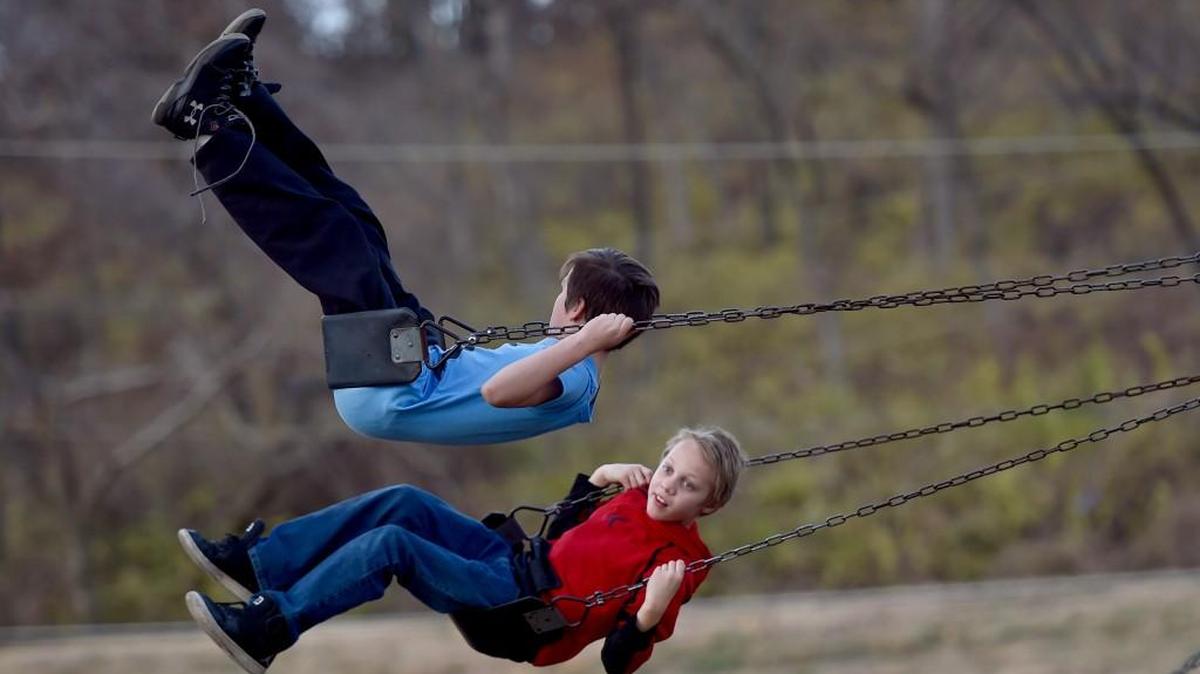 Friday afternoon’s warm weather brought 11-year-olds Donovan Stone (in red shirt) and Douglas Carlock out for some fun in Macken Park in North Kansas City.