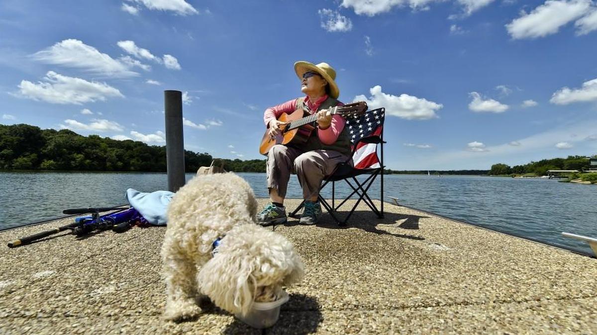 Wendy Kim of Overland Park serenaded the fish and her 18-year-old toy poodle, Happy, before trying her luck with fishing at Shawnee Mission Park in Shawnee. Kim lives in one of the least-stressed cities in the country, according to an analysis.