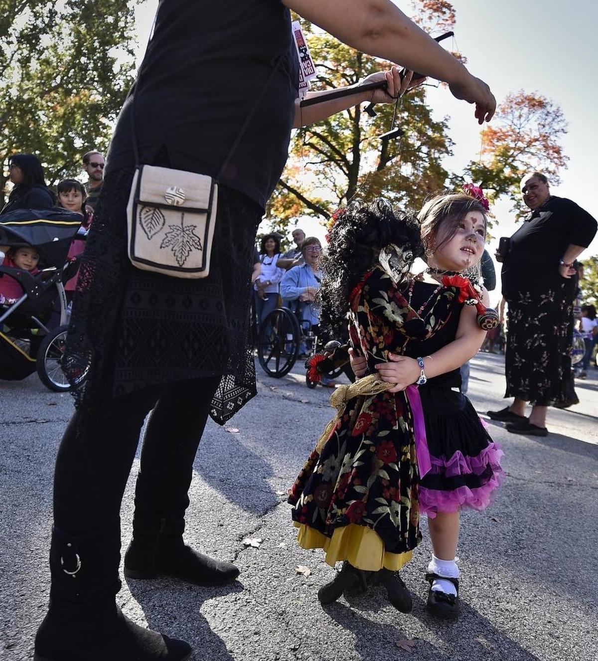 Isabelle Gonzalez of Olathe hugged a calaca operated by Heather Loewenstein of Stone Lion Puppets in 2016.