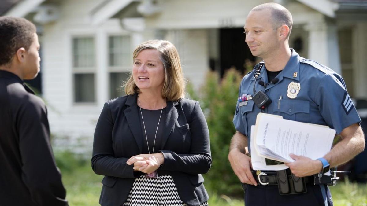 En esta foto de archivo, el agente Jake Becchina explica a Mekai Kelly, de 16 años, de Kansas City, los peligros de los disparos en las celebraciones. Michele Shanahan DeMoss, cuya hija de 11 años Blair Shanahan Lane murió por disparos en 2011, ha ido de puerta en puerta con la  policía durante tres años seguidos para ayudar a educar al público.