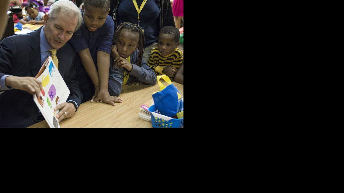 
Thomas Ramsey (from second from left), 9, Jah’nya Jackson, 10, and Del Holmes, 4, gathered around Burns & McDonnell CEO Greg Graves as he read “Brown Bear, Brown Bear, What Do You See?” on Thursday at Faxon Elementary School. 
