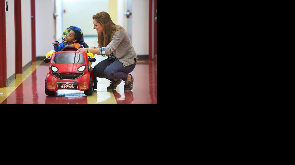 
Mallory White, a physical therapy student from Rockhurst University, guided Trace Bales, 3, as he drove his new battery powered car down the hall at the Children’s Center for the Visually Impaired. As part of a program called Go Baby Go KC, students in the physical therapy program have been modifying off-the-shelf cars for children with special needs.
