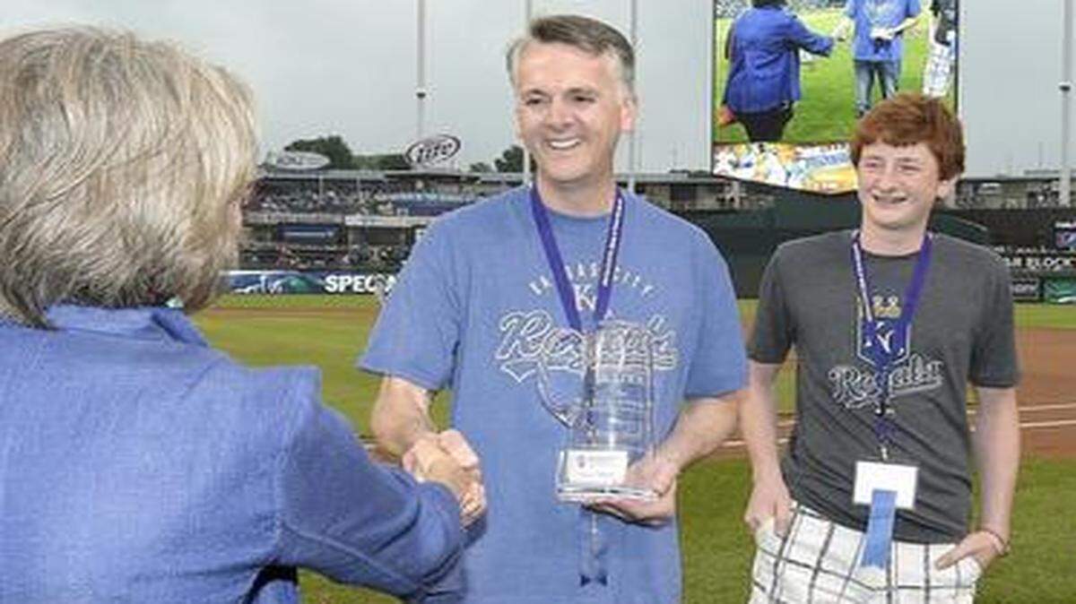 
Steve Huff of Topeka shook hands with Janie Quisenberry as his son, Braxton, 15, looked on after Huff was named the 2014 Kansas City Father of the Year before Tuesday’s Royals  game at Kauffman Stadium. More than 1,000 students submitted entries for the award given by the National Center for Fathering.
