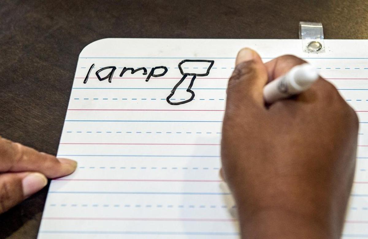 Rupa, a refugee from Bhutan, learns to write “lamp” during an American Sign Language class in Kansas City, Kan., for deaf refugees. The Rev. Debbie Buchholz, who is hard of hearing herself, runs a program for deaf refugees through her Olathe church.