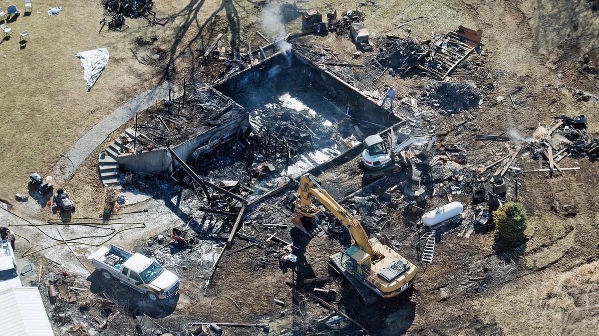 Investigators used heavy equipment to examine the remains of a house that burned Friday night and killed four people just south of Edgerton, Mo.