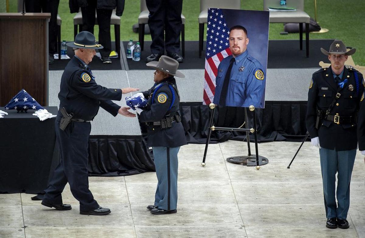 The flag that had been covering the casket of Wyandotte County deputy Patrick Rohrer was prepared for presentation to his family on Thursday, June 21, 2018, during a funeral for Rohrer and deputy Theresa King at Children's Mercy Park in Kansas City, Kan.