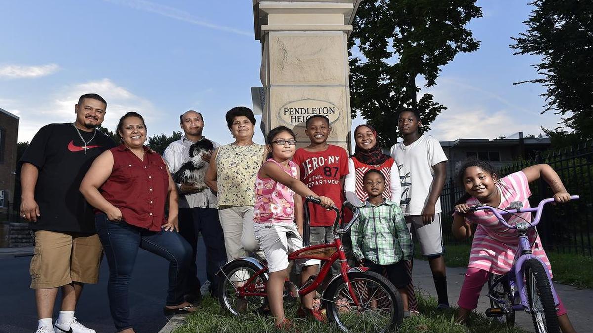 
Neighbors such as Marcos and Aby Olbera (left), with Aby’s parents (third and fourth from left) and members of the Qadi and Mohamed families (right) regularly socialize and the children play together in Kansas City’s Pendleton Heights neighborhood.
