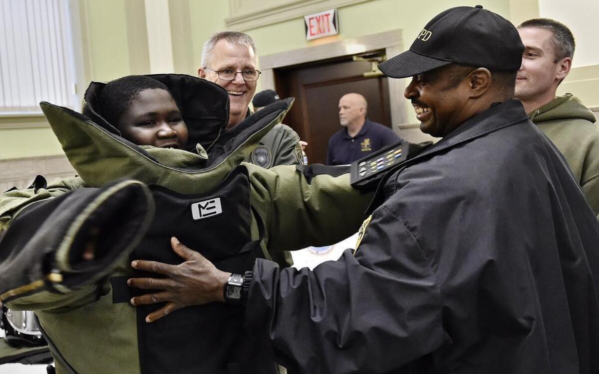
Ramone Ward II (from left), 13, got to feel the bulk of a bomb suit at a forum with local law enforcement Wednesday. Kansas City, Kan., bomb squad technicians Robert Baumli, Romulo O’Reilly (wearing hat) and Jeff Gardner helped him put it on. 

