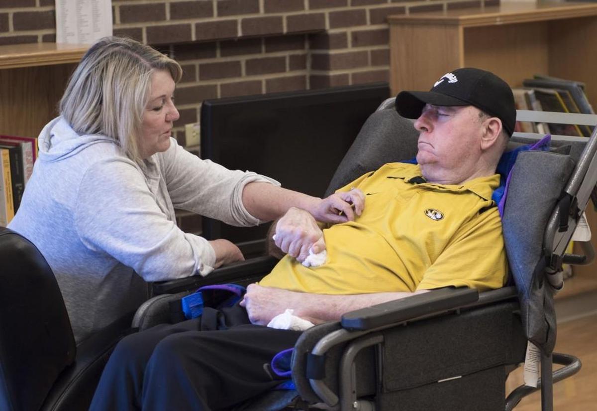Norma Brown with her husband Ray Brown at the Missouri Veterans Home in Warrensburg. Ray, unable to speak or move after several strokes, is a Vietnam vet who earned a Purple Heart. Norma has been unable to get VA benefits for Ray even though she’s been told by some that his case is a “slam dunk.”