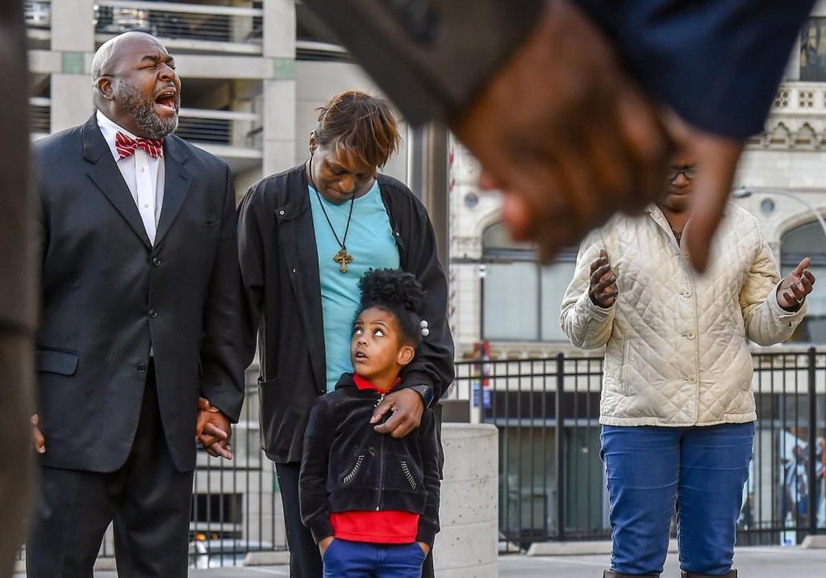 Vernon Percy Howard Jr (left)., president of the Southern Christian Leadership Conference of Greater Kansas City and senior pastor at St. Mark Union Church in Kansas City, led a prayer during a vigil Wednesday for Ryan Stokes. Stokes’ mother, Narene Stokes-James, and his 4-year-daughter, Neriah Stokes joined the event at the corner of 12th and McGee streets in downtown Kansas City, near where Stokes was fatally shot by police in 2013. The Southern Christian Leadership Conference of Greater Kansas City has asked the U.S. attorney general’s office and the FBI to investigate the shooting. A grand jury declined to indict the officer who shot Stokes.