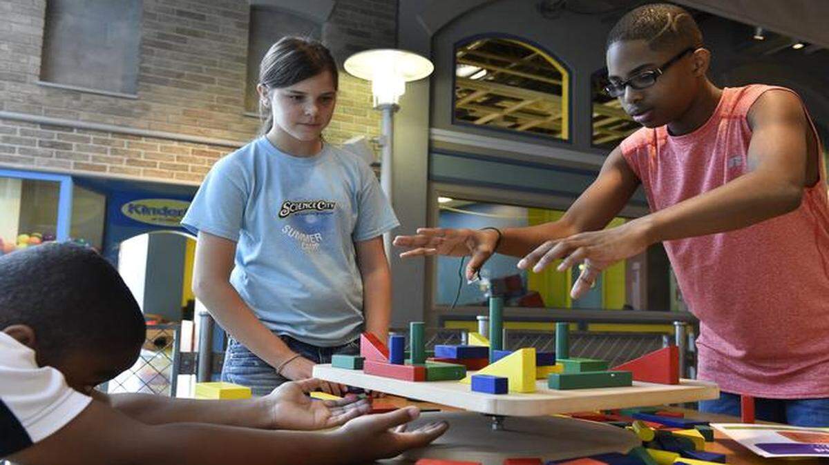
Spark!Lab opens Tuesday at Science City in Union Station, but summer campers got a sneak peek of the new attraction on Monday, trying such activities as the Towering Teeter Table, which encourages risk taking, among other things. Ten-year-old Peyton Carter of Kansas City (from left) prepared to break the teeter as Kya Vulgamott of Kansas City, 10, waited her turn and watched Joseph McCray of Kansas City, Kan., 12, successfully apply another block on the table.
