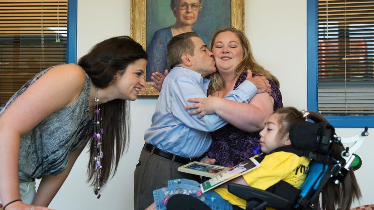 
Alissa LaManno, 24, (left) talked to Layna Talbott, 5, a student at the Children’s Center for the Visually Impaired, as her father, Jim LaManno, gave a kiss to Layna’s mother, Katherine Talbott, after CCVI announced Layna as one of two student recipients for the Teresa R. LaManno Scholarship for the 2015-16 school year. 
