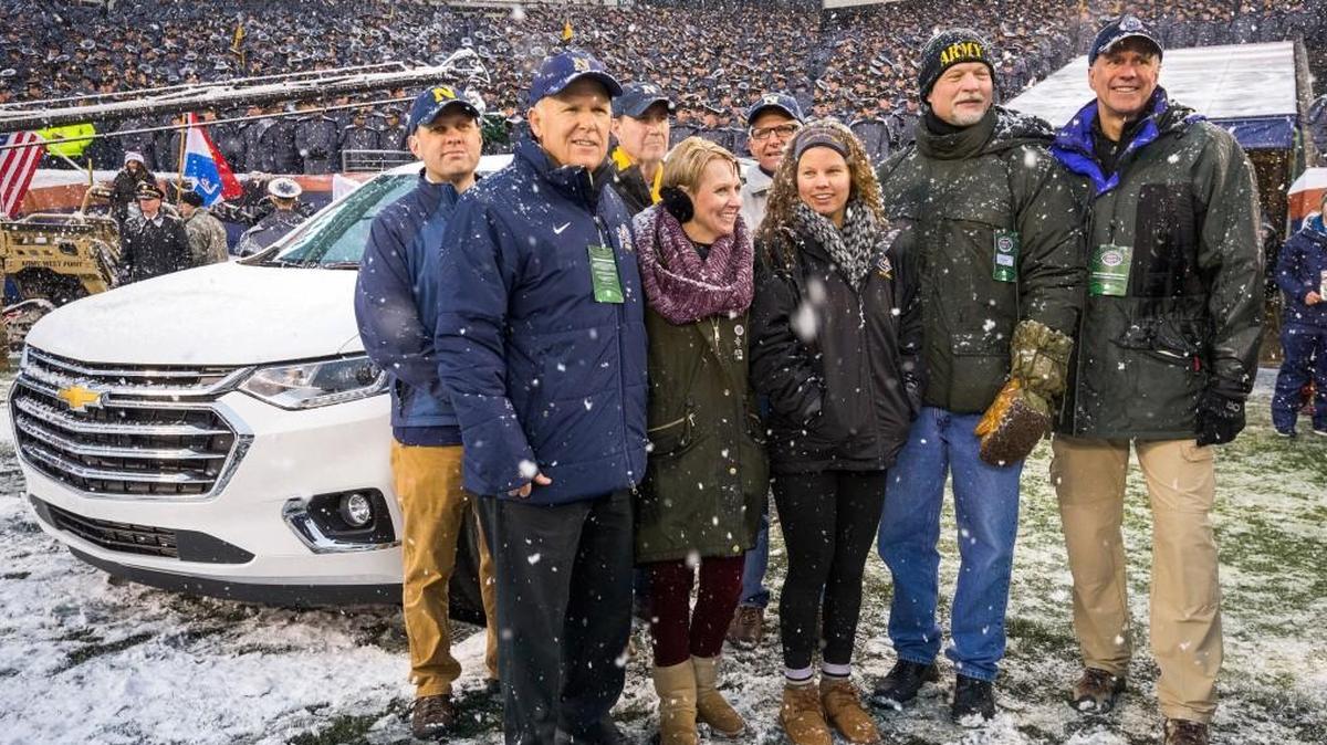 Dan Akerson, (left) former chairman and CEO of General Motors and a U.S. Naval Academy graduate, presented Shawn Moore (standing next to him) with a 2018 Chevrolet Traverse at the Army-Navy game today in Philadelphia. She was honored for her work with Operation Homefront’s Hearts of Valor, an organization that honors the service and sacrifice of those who care for wounded soldiers. Her husband, Bryan Moore, is the second to the right.