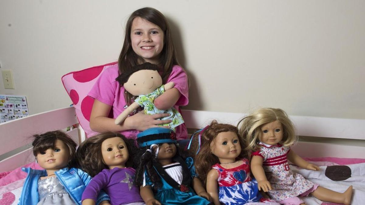 Jordan Reeves displays her American Girl dolls, while holding her favorite doll, which she calls Little Boo.