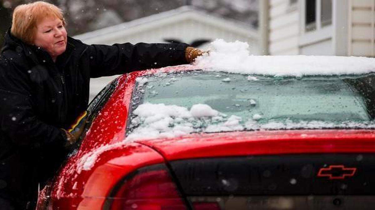 
Gail Bornaman of Independence cleaned snow off her car in the snow on Sunday.
