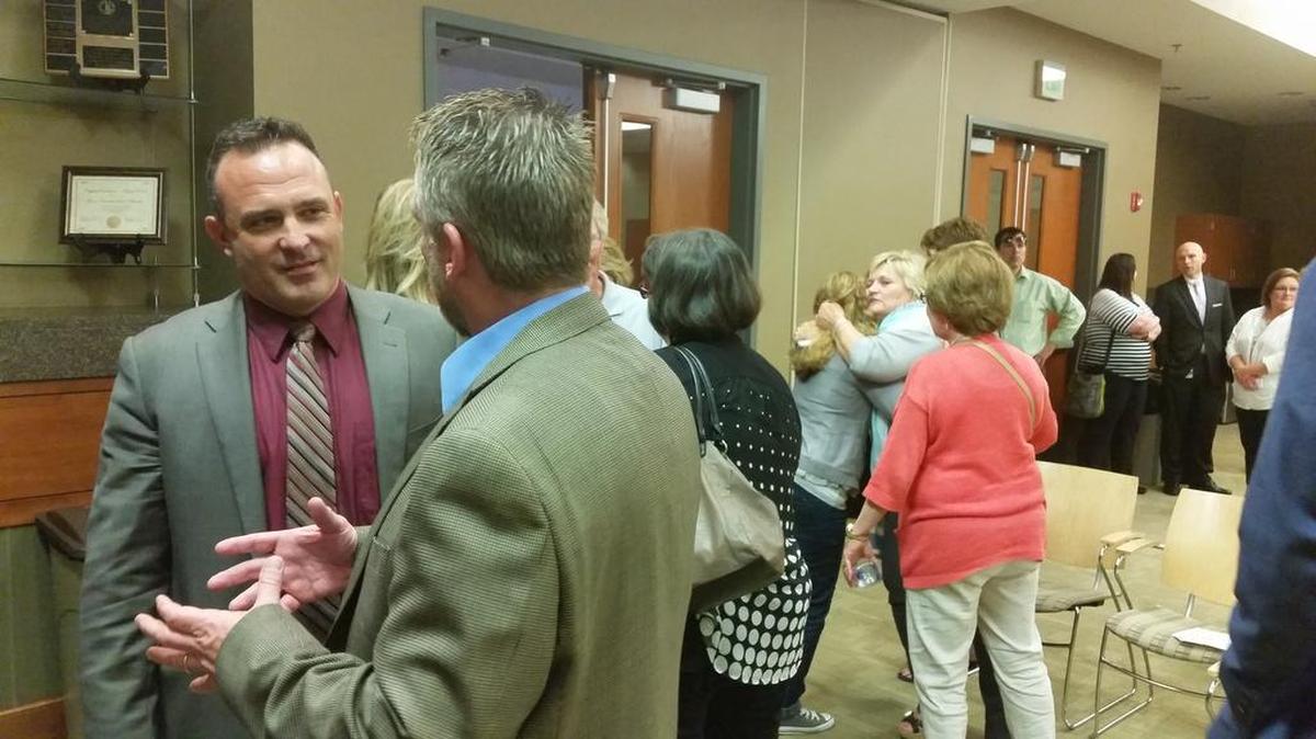 Lee’s Summit school board member Bill Baird (left) spoke with a member of the public after the board’s monthly meeting Thursday in Lee’s Summit.