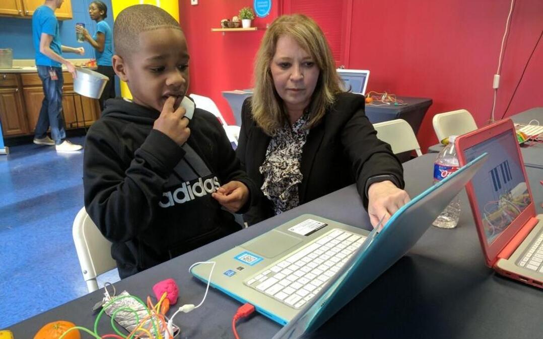 Jaylen Bates works with Tina Krstulic of Surplus Exchange on a computer program at the West Bluff public housing complex. Google Fiber has been giving free internet service there for a year.