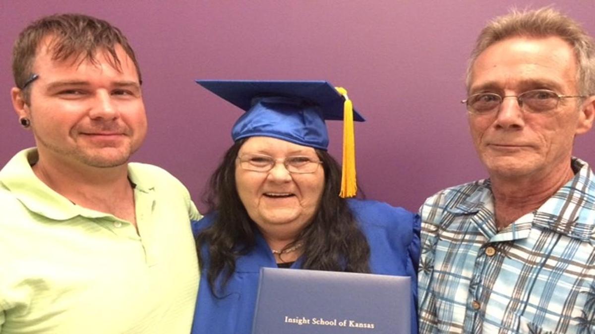 Judy Renton, 55, with husband Michael Lefebyre and son Everett James, shows off the high school diploma she received on Saturday.