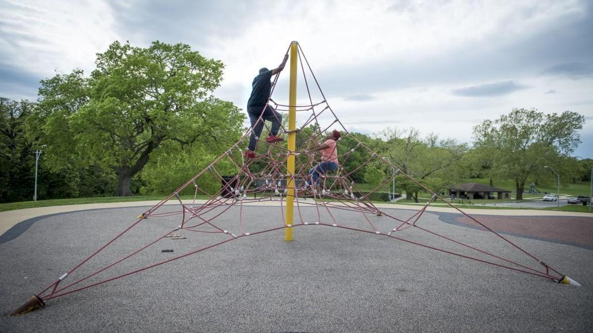 Spring Valley Park boasts a newer padded playground, a walking trail, a popular shelter, ball fields and a fountain. Booker Watson (left), 21, of Kansas City, and Tierra Berry, 21, of Kansas City, climb a rope pyramid at the park.