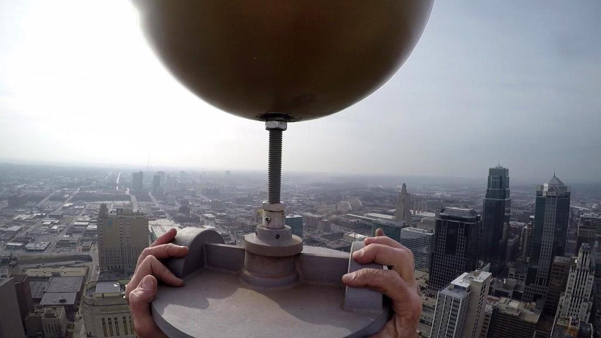 Steeplejack Jim Phelan tightened the wobbly brass ball at the top of City Hall’s flagpole on Tuesday. He also repaired the pulleys and strung the pole with fresh ropes.