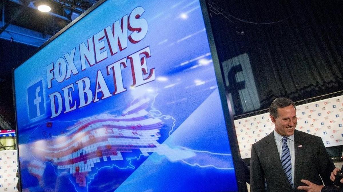 
Former Sen. Rick Santorum speaks to a reporter as he makes his way through the media center at Quicken Loans Arena in Cleveland, the site of Thursday’s GOP presidential debate. Santorum has not qualified for the prime time debate and will be participating in a pre-debate forum with six other non-qualifying candidates. 
