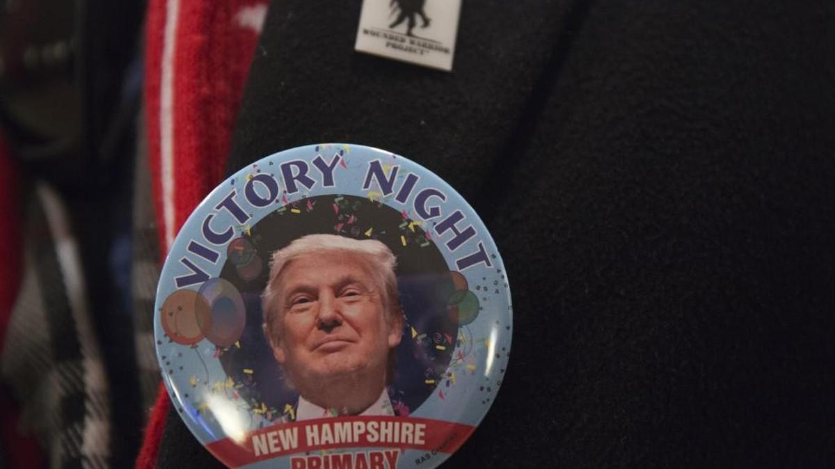 An attendee wears a victory campaign button for Donald Trump on Tuesday.
