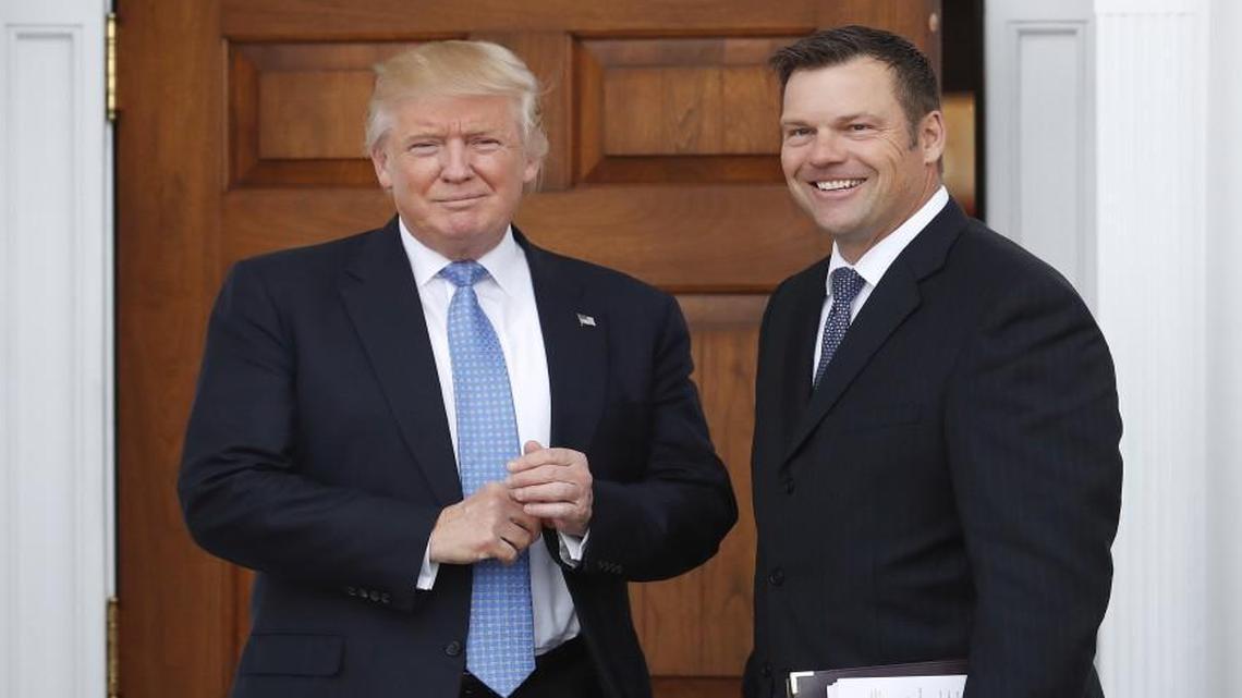 In this Nov. 20, 2016, file photo, Kansas Secretary of State Kris Kobach, right, holds a stack of papers as he meets with then President-elect Donald Trump at the Trump National Golf Club Bedminster clubhouse in Bedminster, N.J.