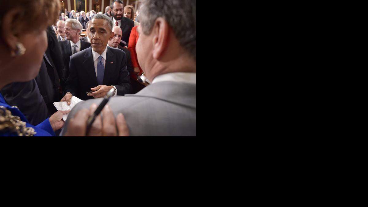
President Barack Obama signs autographs after delivering his State of the Union address before a joint session of Congress, Tuesday, Jan. 20, 2015, on Capitol Hill in Washington.(AP Photo/Mandel Ngan, Pool)
