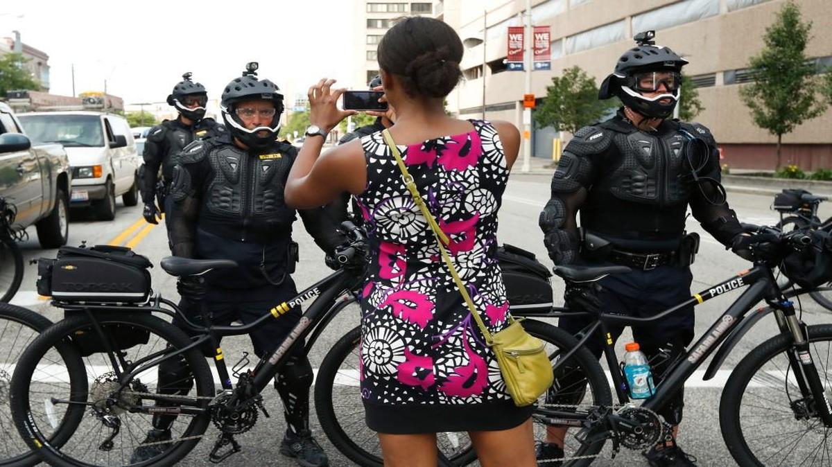 A demonstrator took a picture of the police line during the “Shut Down Trump & the RNC” protest on Sunday in Cleveland. The Republican National Convention starts Monday in the city.