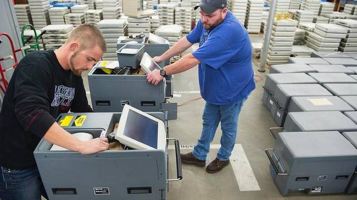 
Dakota Bossow, (left), an election technician, and Jon Geib, warehouse manager, worked on an Inka Vote precinct ballot counting machine on Monday, Nov. 24, 2014, at the Jackson County Election Board warehouse in Independence. TAMMY LJUNGBLAD The Kansas City Star
