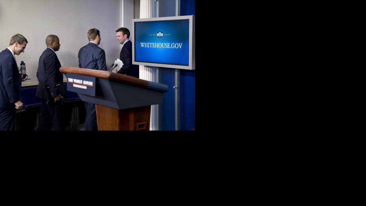
New White House press secretary Josh Earnest, right, looks back toward members of the media as he exits with staff at the conclusion of his first briefing as press secretary on Monday. 

