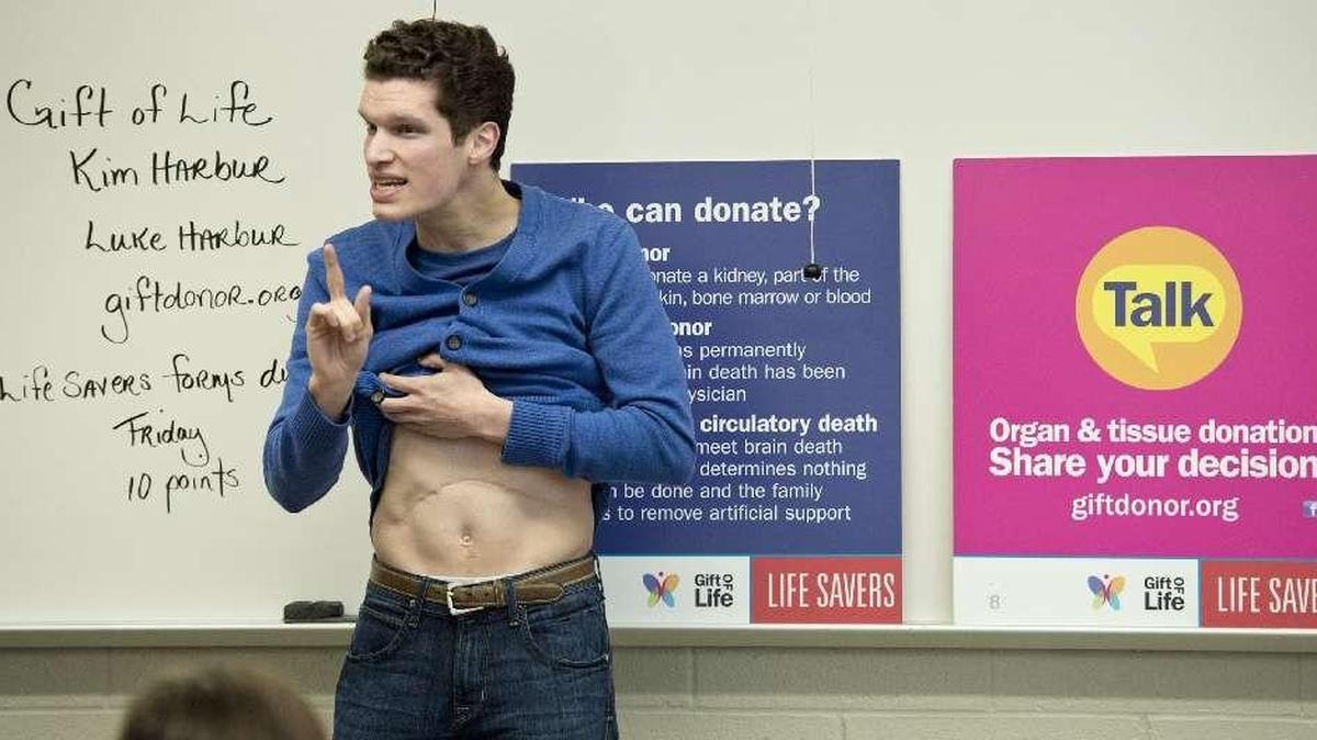 Liver transplant recipient Luke Harbur tells the story of his transplant that he received as an infant, as he shows his scar during a high school organ and tissue donor presentation on January 8, 2014.