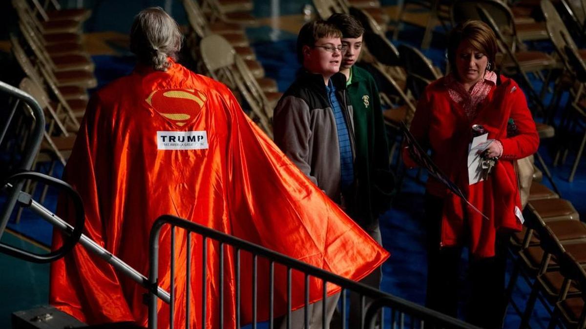 A man in a Trump superman cape departs at a Trump rally last month. It’s the candidate who’s looking super these days.